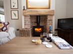 Snuggle up in front of the wood burner and enjoy a glass of wine Snuggle up in front of the wood burner and enjoy a glass of wine