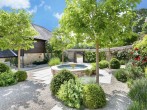 Idyllic garden with a trickling water feature and seating area Idyllic garden with a trickling water feature and seating area